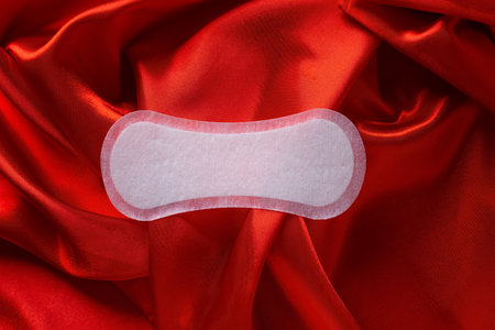 Female intimate care concept. Daily panty for hygiene on elegant satin fabric materialの写真素材