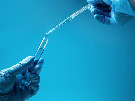 Pipette drip drops into laboratory test glass tubes, nobody. Closeup. Blue toneの写真素材