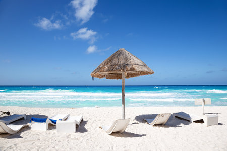 Caribbean sea coastline with grass sun umbrella and wooden beach beds. vacation conceptの写真素材