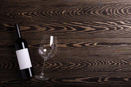 Glass and bottle with red wine on wooden rustic background. Flat layの写真素材