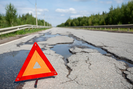 Red triangle emergency stop sign on asphalt road. Closeup. Nobodyの写真素材
