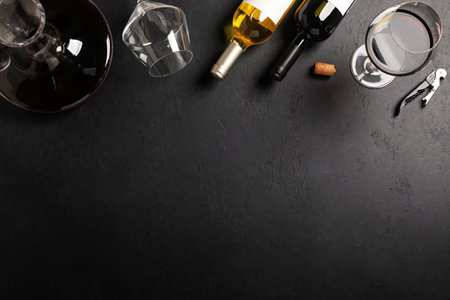 Decanter, glass and bottles with red and white wine on black background. Flat layの写真素材