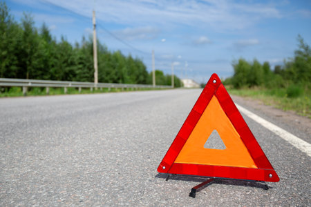 Red triangle emergency stop sign on asphalt road. Closeup. Nobodyの写真素材