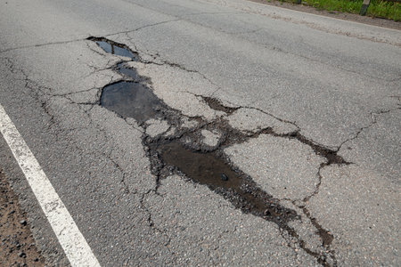 Potholes on bad asphalt road. Closeup. Nobodyの写真素材