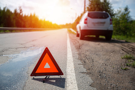 Car and red triangle emergency stop sign on asphalt road. Closeup. Nobodyの写真素材