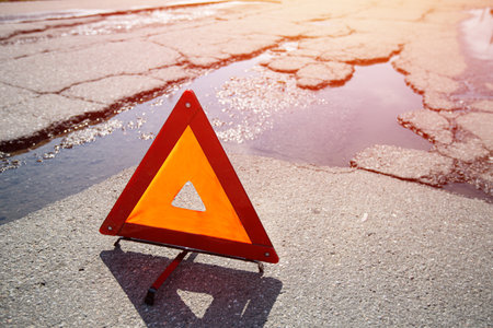 Red triangle emergency stop sign on asphalt road. Closeup. Nobodyの写真素材