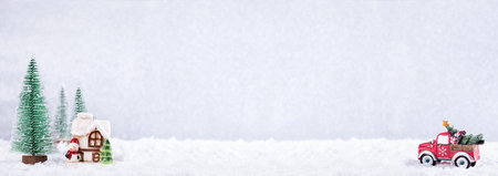 Christmas Car carrying fir tree to Country house over silver background with New Year spruce trees on snow. Winter holidays. Long bannerの写真素材