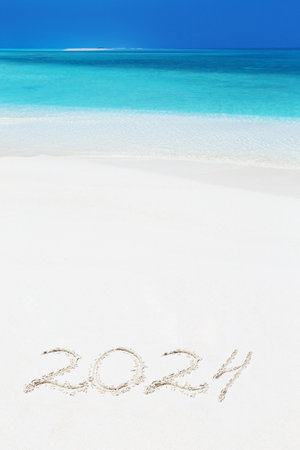 Handwriting inscription numbers 2024 on perfect tropical sandy beach, travel vacation and winter holidaysの写真素材