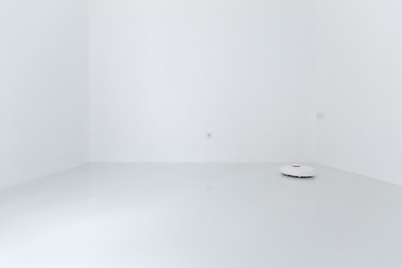 Vacuum cleaner cleaning white glass ceramic tile floor in empty room, selective focusの写真素材