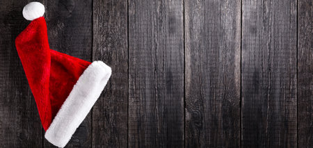 Santa Claus hat on wooden rustic background. Christmas and new year celebration. Long bannerの写真素材