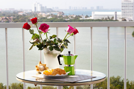 Delicious breakfast with coffee, fresh croissants and slice of orange fruit on hotel's balcony, Nobodyの写真素材
