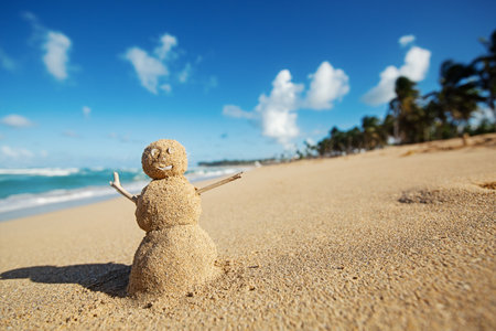 Caribbean Christmas Snowman made out of sand on sandy beach. Holiday vacation in hot countries concept. New Year travel greeting card with copy space.の写真素材