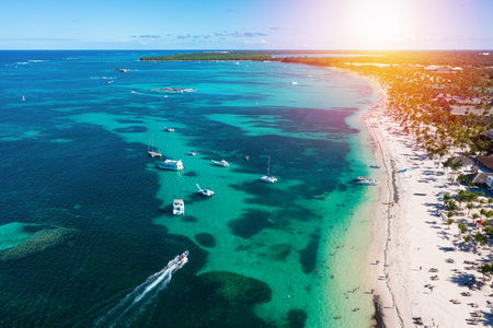 Tropical coastline with resorts, palm trees and Caribbean sea with floating boats. Travel destinations. Dominican Republic. Aerial viewの写真素材