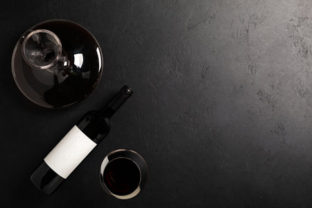 Decanter, glass and bottle with red wine on black background. Flat layの写真素材