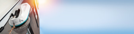 Vacuum cleaner washing windows. Home appliance and technology concept. Closeup. Long bannerの写真素材