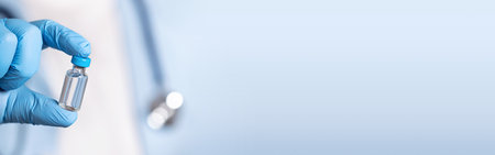 Doctor in blue latex gloves holding glass vial with vaccine, closeupの写真素材