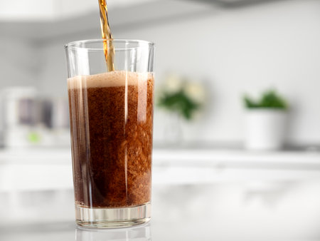 Pouring fizzing beverage in glass at the kitchen, closeupの写真素材