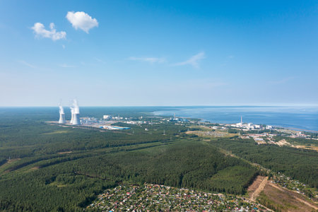 Smoking cooling towers at nuclear power plant located on seaside. Aerial view from droneの写真素材