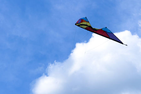 Kite on a blue sky background with cloudsの写真素材