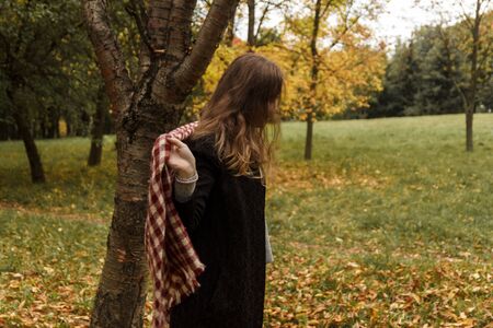 The girl is sitting on the bedspread in autumnの写真素材