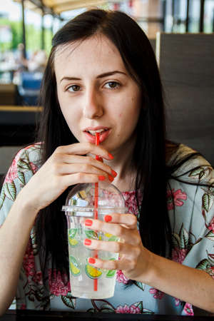 Girl drinks cocktail from a tubeの写真素材