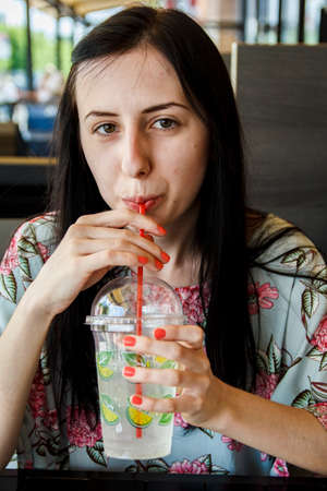 Girl drinks cocktail from a tubeの写真素材