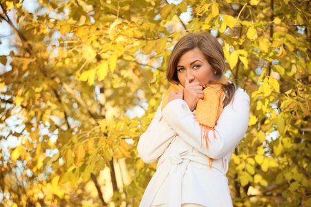 beauty in white coat against yellow tree
