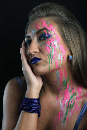 beauty with paint-stained face on black