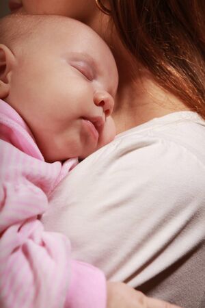 little baby asleep on mother's chestの写真素材