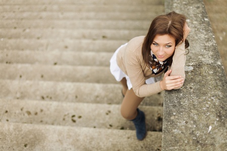beautiful young woman posing on stairsの写真素材