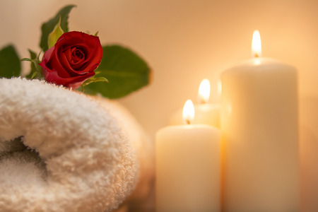 red rose, burning candles and towels in spa compositionの写真素材