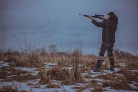 a hunter with a gun in autumn field, Russiaの写真素材