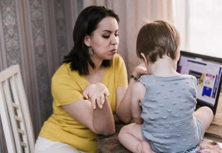 Happy young mother and her daughter using a laptopのeditorial素材