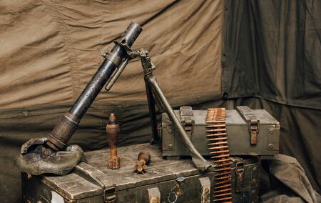 A mortar of the Red Army in World War II stands on a box for cartridges, next to a mine and machine-gun belt. Vintage styleの写真素材