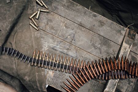Machine gun belt with cartridges for MG 34-42 of the USSR on a wooden background. Top view, place...