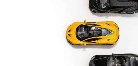 Sports toy cars - races - yellow one race lead. White background, top view