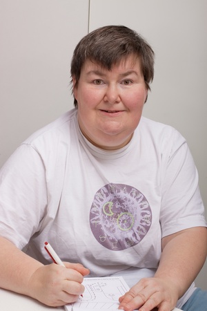a sitting mentally disabled woman is painting a pictureの写真素材