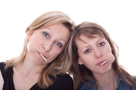 two young woman with sweets are looking to viewerの写真素材