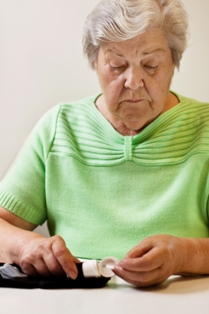 old woman with test strips of blood sugar testの写真素材