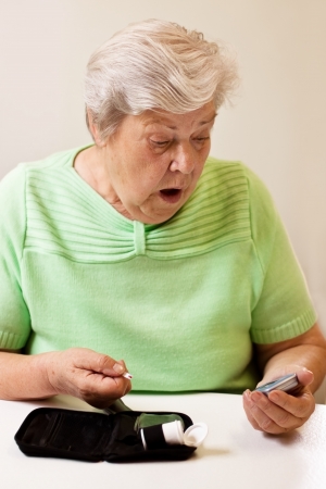 old woman in blood sugar measure is shocked by the valuesの写真素材
