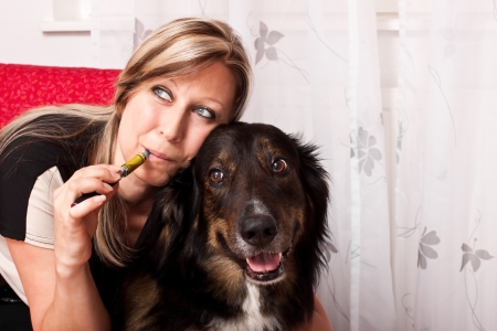 pretty blonde woman with mixed breed dog evaporated E Cigaretteの写真素材