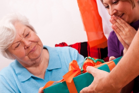 female pensioner gets a gift, young woman is happy aboutの写真素材