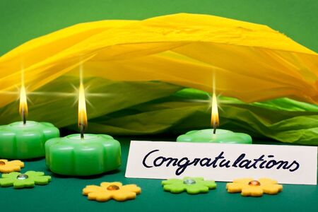 green-yellow background with candles and text sign congratulationsの写真素材