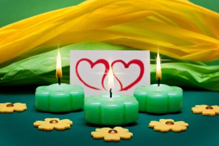 green-yellow background with candles and two heartsの写真素材