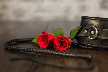 closeup from bdsm toys and a red roseの写真素材