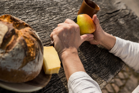 a man is cutting a apple in the natureの写真素材