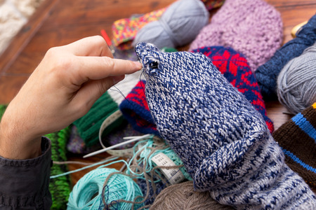 closeup of male hands darn wool socks