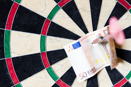 closeup of a Dartboard with Steeldarts and euro in itの写真素材