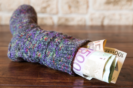sock full of money on a tableの写真素材