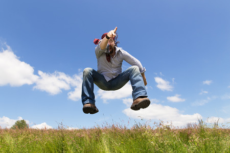 a man with beard is jumping and points to somethingの写真素材